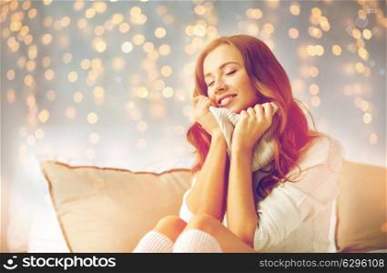 christmas, winter, comfort and people concept - happy young woman in warm pullover at home. happy young woman in warm pullover at home