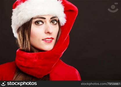 Christmas winter happiness concept. Woman wearing santa helper hat portrait on dark black background