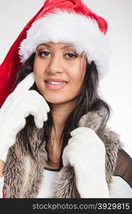 Christmas winter happiness concept. Young woman girl mixed race wearing santa helper hat fur portrait. Gray background