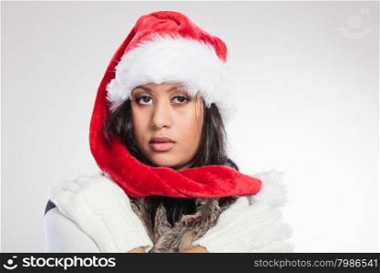 Christmas winter happiness concept. Young woman girl mixed race wearing santa helper hat fur portrait. Gray background