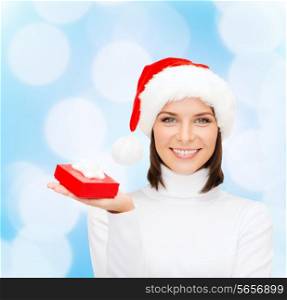 christmas, winter, happiness, holidays and people concept - smiling woman in santa helper hat with small red gift box over blue lights background