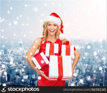 christmas, winter, happiness, holidays and people concept- smiling woman in santa helper hat with gift box over snowy city background