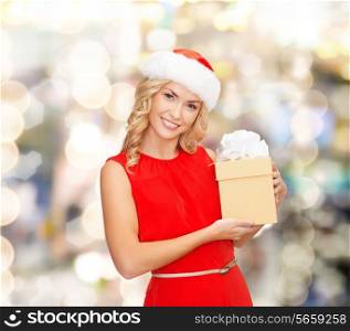 christmas, winter, happiness, holidays and people concept- smiling woman in santa helper hat with gift box over lights background