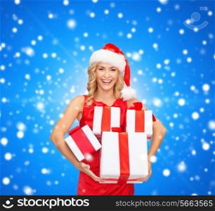 christmas, winter, happiness, holidays and people concept- smiling woman in santa helper hat with gift box over blue snowy background