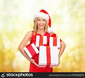 christmas, winter, happiness, holidays and people concept- smiling woman in santa helper hat with gift box over yellow lights background