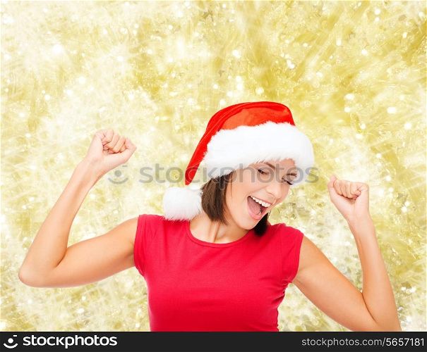 christmas, winter, holidays, happiness and people concept - smiling woman in santa helper hat and blank red shirt over yellow lights background