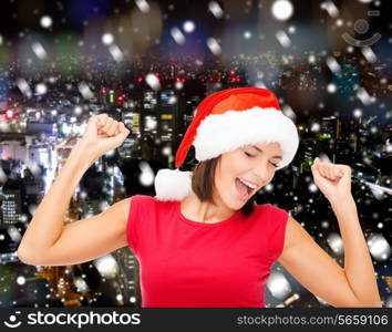 christmas, winter, holidays, happiness and people concept - smiling woman in santa helper hat and blank red shirt over snowy night city background