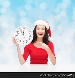 christmas, winter, holidays, time and people concept - smiling woman in santa helper hat and red dress with clock over blue lights background