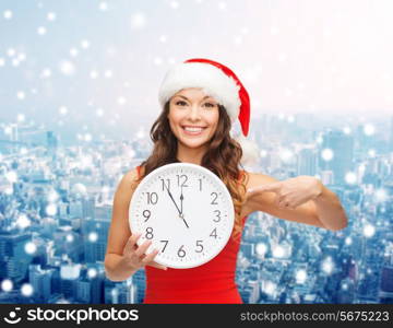 christmas, winter, holidays, time and people concept - smiling woman in santa helper hat and red dress with clock over snowy city background