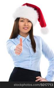 Christmas woman showing thumbs up. Young smiling woman with red santa hat. Image of beautiful young Asian model isolated on perfect white background.
