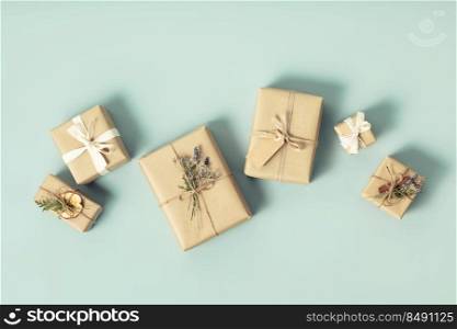 Christmas wrapping idea. Eco-Friendly, Sustainable, zero waste, natural color Christmas gift boxes on blue background