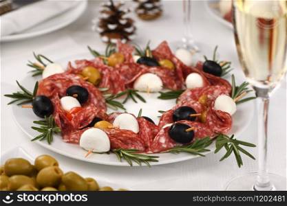 Christmas wreath - antipasto. Salami canapes with olives, baby mozzarella.