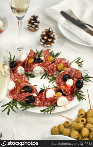 Christmas wreath - antipasto. Salami canapes with olives, baby mozzarella.