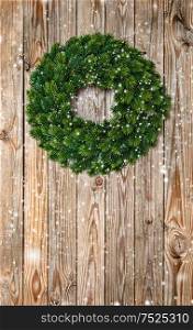 Christmas wreath decoration on rustic wooden background. Vintage style dark toned picture
