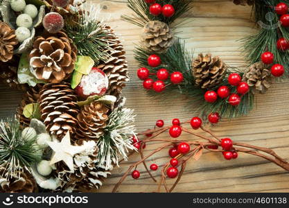 Christmas wreath formed by natural elements and branch with red fruits