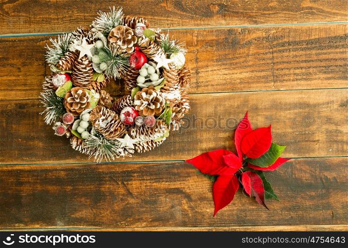 Christmas wreath formed by natural elements and red flowers