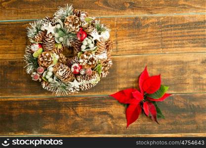 Christmas wreath formed by natural elements and red flowers
