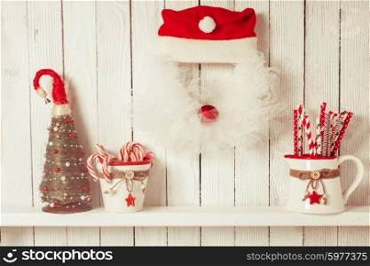 Christmas wreath like Santa and shelf on wooden wall. Christmas wreath like Santa