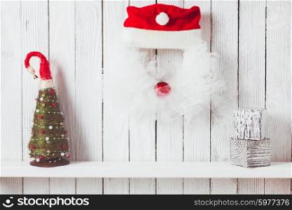 Christmas wreath like Santa and shelf on wooden wall. Christmas wreath like Santa
