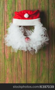 Christmas wreath like Santa head from lace and red bauble on the wooden door. Christmas wreath like Santa