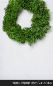 Christmas wreath natural fir braided circle on white concrete wall with copy space
