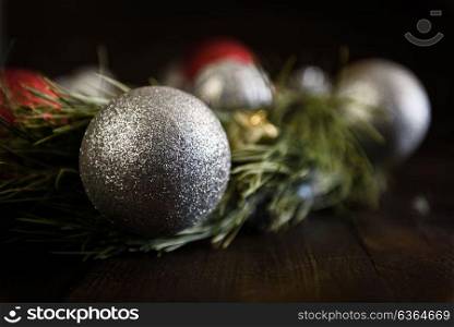 Christmas wreath of fir branches with Christmas decorations, pine cones and gifts on the brown background