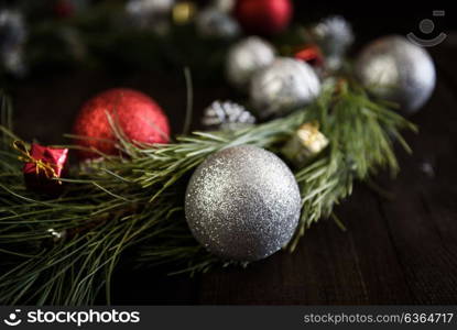 Christmas wreath of fir branches with Christmas decorations, pine cones and gifts on the brown background