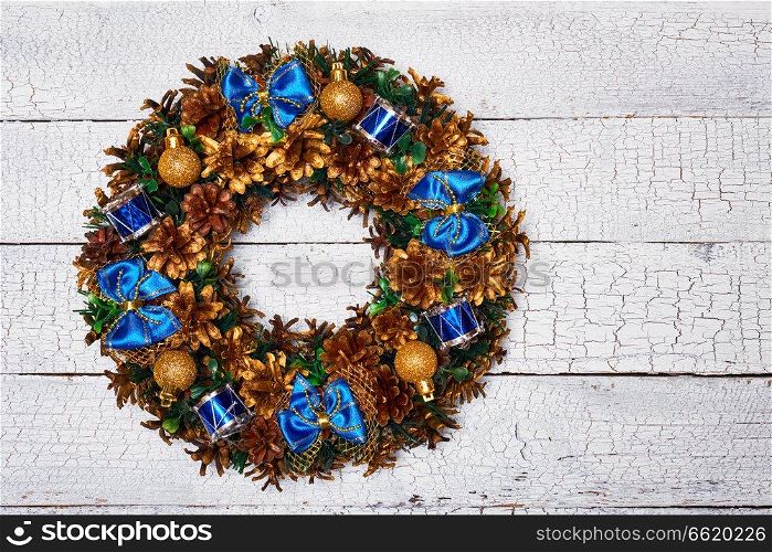 Christmas wreath on white painted wooden background. Christmas wreath top view