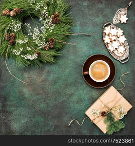 Christmas wreath, star cookies, coffee and wrapped gift. Vintage style toned picture