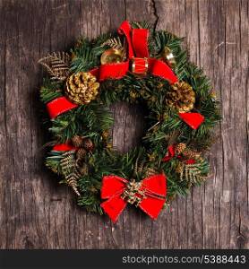 Christmas wreath with decorations on the rustic wooden background