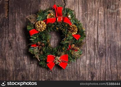 Christmas wreath with decorations on the rustic wooden background
