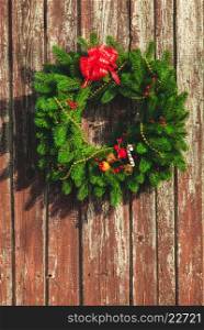 Christmas wreath with decorations on the shabby wooden door.. Christmas wreath