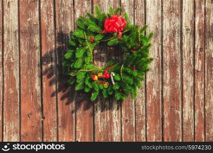 Christmas wreath with decorations on the shabby wooden door.. Christmas wreath