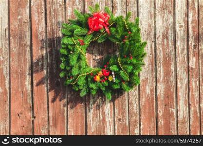 Christmas wreath with decorations on the shabby wooden door.. The Christmas wreath