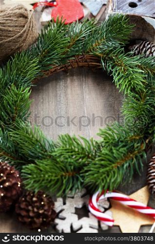 Christmas wreath with decorations on wooden background