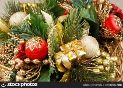 Christmas wreath with leaves, gift, ribbon and baubles