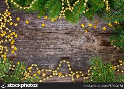 christmas wreath with lights. christmas fresh evergreen tree branches with golden christmas decorations on wooden background