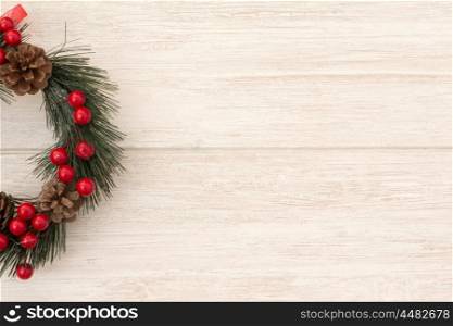Christmas wreath with pine cones and red berries on a grey background