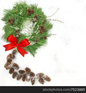 Christmas wreath with pine cones garland and red ribbon bow