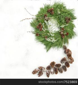 Christmas wreath with pine cones garland on bright stone background