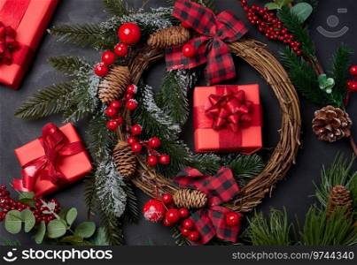 Christmas wreaths, fir branches and gifts on a black background. View from above