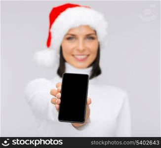 christmas, x-mas, electronics and gadget concept - smiling woman in santa helper hat with blank screen smartphone