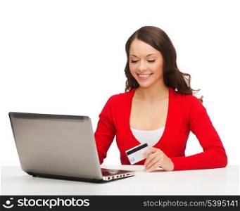 christmas, x-mas, electronics, gadget concept - smiling woman in red clothes with laptop computer and credit card
