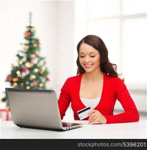 christmas, x-mas, electronics, gadget concept - smiling woman in red clothes with laptop computer and credit card