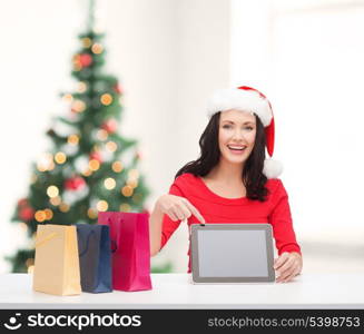 christmas, x-mas, electronics, gadget concept - smiling woman in santa helper hat with blank screen tablet pc