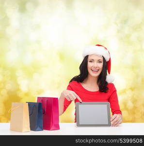 christmas, x-mas, electronics, gadget concept - smiling woman in santa helper hat with blank screen tablet pc