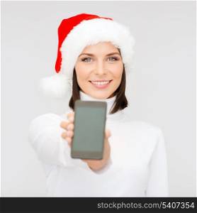 christmas, x-mas, electronics, gadget concept - smiling woman in santa helper hat with blank screen smartphone