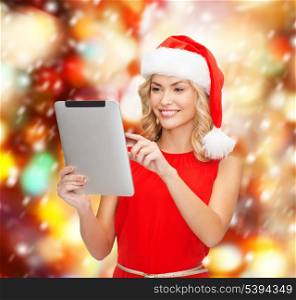 christmas, x-mas, electronics, gadget concept - smiling woman in santa helper hat with tablet pc