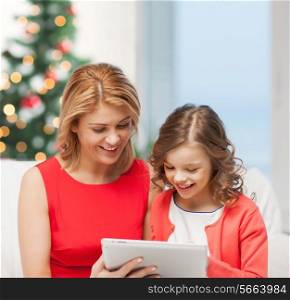 christmas, x-mas, happiness, modern technology concept - mother and daughter with tablet pc