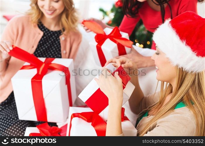 christmas, x-mas, happiness, winter and people concept - three women in santa helper hats holding many gift boxes